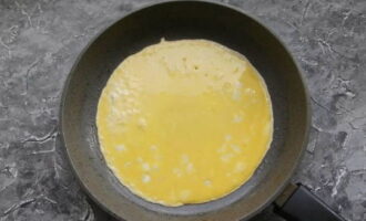 Heat a frying pan with vegetable oil and pour in the whipped yolks, distributing evenly.