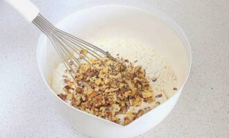 Pour the nuts into the flour mixture, reserving a little for sprinkling, and stir again.