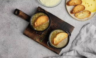 Despeje a sopa em panelas de barro, coloque pedaços de baguete por cima, submergindo-os levemente na composição principal.