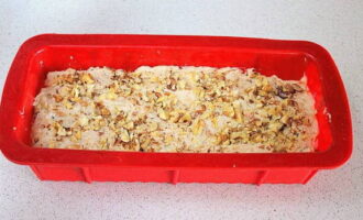 Place the kneaded dough in an even layer in a baking dish that does not need to be greased. Sprinkle the top of the dough evenly with nut crumbs.