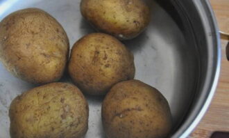 Lavate bene le patate sotto l'acqua corrente, mettetele in una pentola, coprite con acqua e mettete a cuocere. Controllate se le patate sono cotte forandole con una forchetta: devono entrare e uscire facilmente.