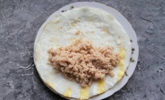 Remove the omelette from the pan and, without turning it over, place it on a plate and spread the rice mixture.