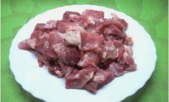 Enjuague el lomo de cerdo con agua fría y séquelo con toallas de papel. Luego coloque la carne en una tabla de cortar y córtela en cubos. Sal y sazona la carne, revuelve.