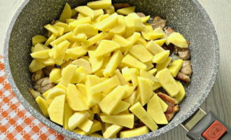 Descasque as batatas e lave-as bem. Corte o vegetal em barras não muito grossas. Quando as cebolas estiverem levemente douradas, coloque as batatas na panela.