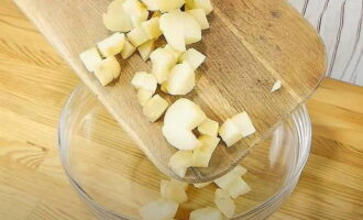 Raffreddare le patate bollite e sbucciarle. Tagliare i tuberi a cubetti. Metti le patate in una ciotola, aggiungi un paio di cucchiai di olio vegetale non raffinato e mescola.