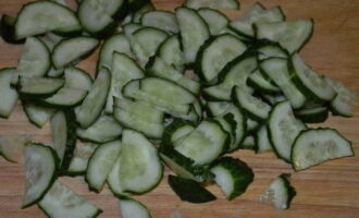 Corta los pepinos en semicírculos y coloca también la verdura en la ensaladera.