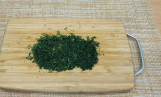 Finely chop a bunch of fresh dill with a knife.