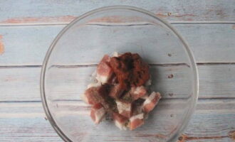 Rinse the pork with water and allow time to dry, cut into medium-sized cubes and transfer to a plate.We supplement the component with tomato paste, salt and ground pepper - mix.