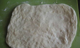 Roll out the finished dough into a thin layer, grease it with vegetable oil.