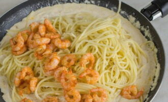 Remove the sauce from the stove. Add strained spaghetti and golden shrimp. 