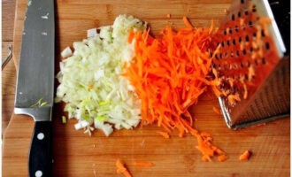 Next, cut the onion into cubes and grate the carrots. 