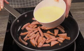 Cut the boiled sausage into small pieces and fry until lightly browned in hot vegetable oil. Pour the omelette mixture over the fried sausage.