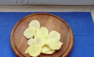 Togliere la buccia alle patate, lavarle e tagliarle a fette.