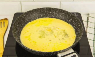 Heat a clean, dry frying pan and grease with butter. Pour the omelette mixture into it.