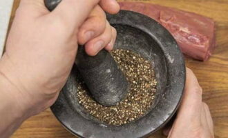 Grind the peppercorns with a pestle or grind them in a coffee grinder.