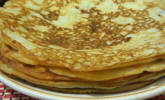 Verhit de braadpan goed en vet deze in met plantaardige olie. Giet het deeg in een pollepel en verdeel het in een gelijkmatige dunne laag. Het is beter om dergelijke pannenkoeken op laag vuur te bakken en onder een afgedekt deksel zal het lekkerder zijn. Bak de pannenkoeken aan beide kanten goudbruin. Als ze niet goed gaar worden, voeg dan een beetje bloem of een ei toe.