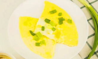 Cut the delicious fluffy omelette with milk into portions prepared in a frying pan, transfer to plates, add chopped greens and serve hot. Bon appetit!