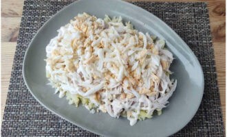 Letakkan telur parut dalam lapisan ketiga. Tidak perlu padat lapisan; salad perlu gebu.