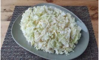 Schneiden Sie die zarten Spitzen der Chinakohlblätter in kleine Quadrate und streuen Sie diese gleichmäßig über den Salat.