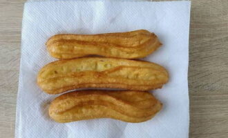 Gatavās churros palielinās apjomā un kļūs zeltainas. Noslaukiet tos no eļļas uz papīra salvetēm.