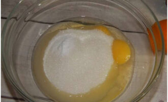 Primero debes preparar las natillas para el pastel. Rompe dos huevos de gallina en un recipiente aparte y agrega dos tipos de azúcar. Batirlos hasta obtener una masa homogénea.