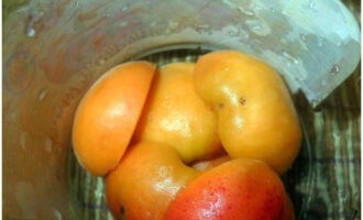 How to cook apricots without cooking with sugar for the winter? We wash the fruits under water, divide them into halves and remove the seeds. Place the prepared apricots in the first layer in sterile jars.