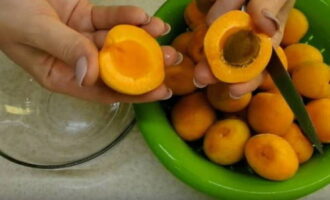 How to prepare a tasty and simple apricot preparation for the winter? Sort the fruits, removing damaged ones, rinse under running water, cut into halves with a sharp knife and remove the seeds.