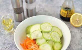 Pagkatapos hugasan ang zucchini at balatan ang mga karot mula sa manipis na alisan ng balat, hiwain nang manipis ang zucchini at i-chop ang mga karot sa shavings sa isang Korean carrot grater. Ilabas ang mga hiwa sa isang lalagyan, budburan ng asin.