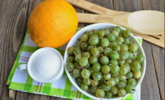 Kami menyusun gooseberries, keluarkan batang dari kedua-dua belah pihak, bilas beri di bawah air yang mengalir dan biarkan mereka dalam colander untuk mengalirkan cecair yang berlebihan. Kupas oren dan potong pulpa menjadi kepingan nipis.