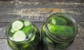 We wash the cucumbers and cut off the tails. Place the vegetables in jars, pour boiling water, cover with a lid and leave for 15 minutes. Then drain the water and repeat the procedure.