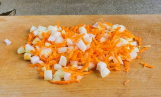 After peeling the carrots and onions, chop the onion into cubes and the carrots using a grater.