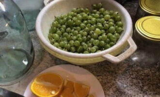 Die Stachelbeeren in ein Sieb geben und unter fließendem Wasser abspülen. Schneiden Sie die Orange in Stücke und vergessen Sie nicht, die Kerne zu entfernen.