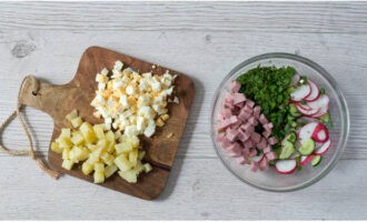 Ilagay ang sausage, gulay, labanos at pipino sa isang malalim na mangkok. Gupitin ang mga pinakuluang itlog at patatas sa mga cube at idagdag ang mga ito sa natitirang mga sangkap.