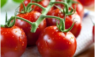 Når tiden er gået, skal du vaske cherrytomaterne og fylde fisken med grøntsager (eller blot placere dem ved siden af). Pak fisken ind i folie og sæt den i ovnen.