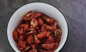 Kami membahagikan tomato berisi yang dibasuh ke dalam segmen, mengeluarkan tangkai. Letakkan dalam bekas.