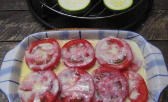 Next, lay out thin circles of tomato. Drizzle with a small amount of sauce.