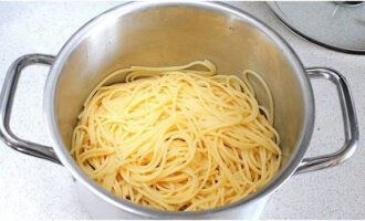 Pour 50 ml of pasta broth. Drain the spaghetti in a colander and immediately return it to the pan, as it is important to keep it hot.