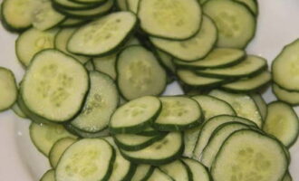 To prepare a finger-licking cucumber salad for the winter, measure out the required amount of vegetables. Wash the cucumbers well and cut into thin slices.