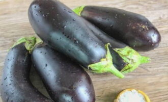 Freeze, or rather prepare, fresh eggplants for freezing for the winter quickly, otherwise they will turn dark. Rinse the eggplants with cold water, dry with a napkin and remove the ends.