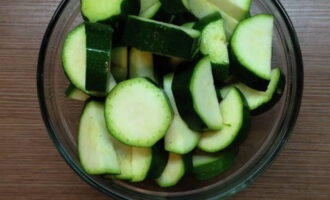 Zucchini dengan kentang dalam ketuhar sangat mudah disediakan. Kami mencuci zucchini dan memotongnya menjadi kepingan.