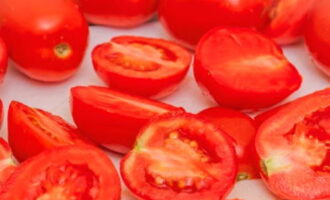 Lavamos bem os tomates, dividimos em metades ou quartos, retirando os talos.