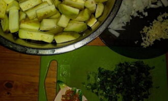 Baklažānus nomizo, sagriež kubiņos un mērcē sālītā ūdenī apmēram 10 minūtes. Sasmalciniet sīpolus, ķiplokus, asos piparus un cilantro.