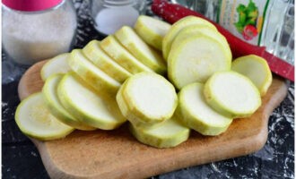 Potong batang zucchini dan potong pulpa menjadi kepingan sederhana tebal.