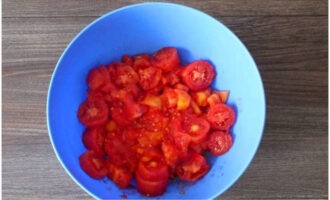 Berhati-hati mengeluarkan tomato dari air panas, keluarkan kulitnya, dan potong pulpa menjadi kepingan sewenang-wenangnya.