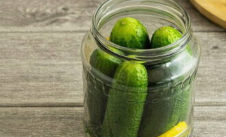 We put the cucumbers and together with them put a slice of seedless lemon into the jar.