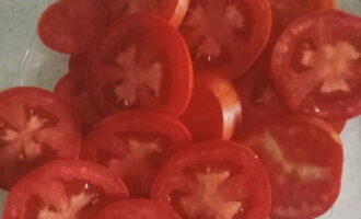 Wash the tomatoes, dry them and cut them into thin slices.