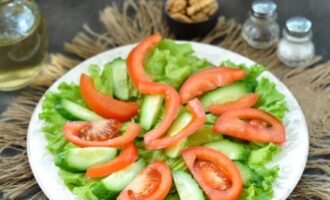 Metti fette abbastanza grandi di pomodori e cetrioli su un cuscino verde.