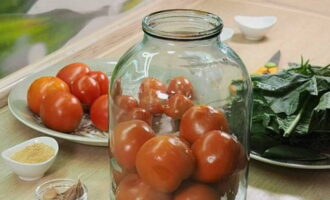 Place the largest fruits on top of the spices, layering them with garlic cloves.