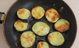 Frite as berinjelas enroladas na farinha em uma frigideira com adição de óleo vegetal. Cozinhe até dourar dos dois lados e coloque sobre papel toalha.Um procedimento simples removerá o excesso de gordura.