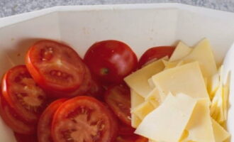 No momento em que as rodelas já estiverem saturadas de aditivos, corte o queijo em rodelas e o tomate em rodelas.